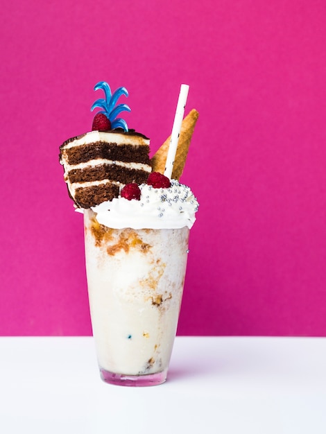 Free photo front view of delicious milshake with ice cream cone and cake