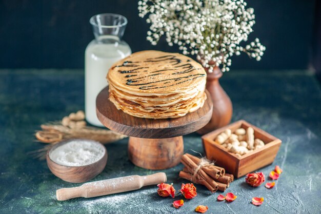 Front view delicious pancakes with milk and nuts on dark blue milk dessert breakfast honey sweet morning pie cake