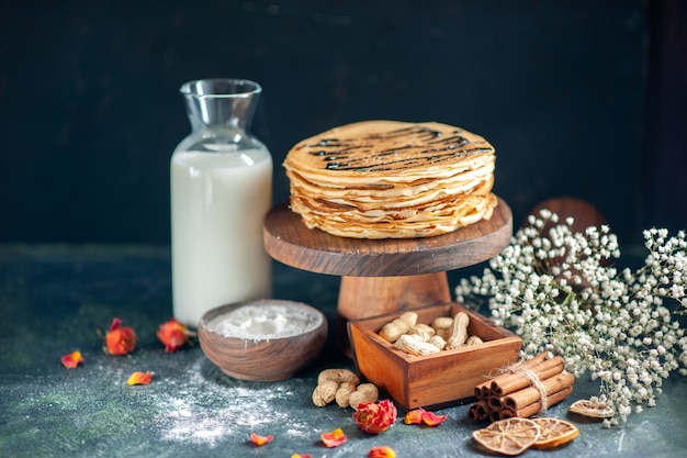 Front view delicious pancakes with nuts on dark-blue milk dessert sweet morning pie honey breakfast