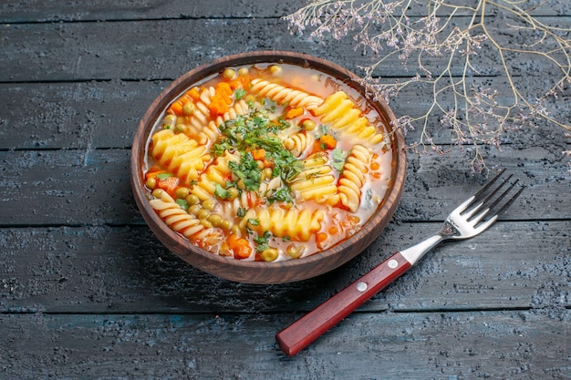 Free photo front view delicious pasta soup from spiral italian pasta with greens on dark rustic desk dinner dish italian pasta soup sauce