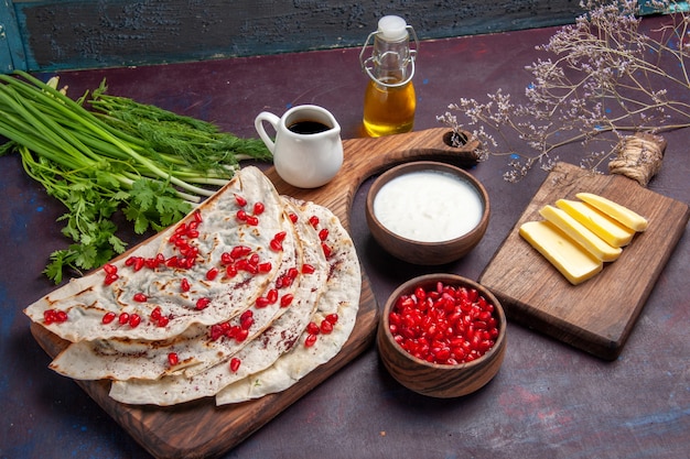 Front view delicious qutabs pitas with meat olive oil and fresh pomegranates on dark surface dough pita meat meal pastry food