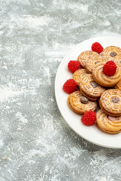 Front view delicious round biscuits with raspberry confitures on a white space