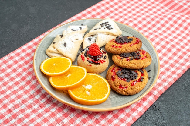 Front view delicious sugar cookies with pastries and orange on dark surface cake sugar biscuit sweet cookies tea