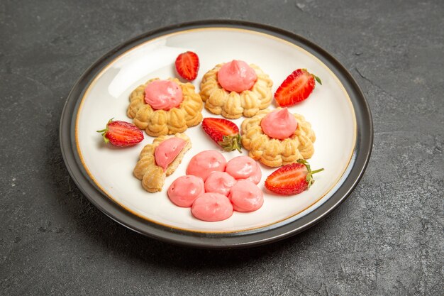 Front view delicious sugar cookies with strawberry jelly on grey space