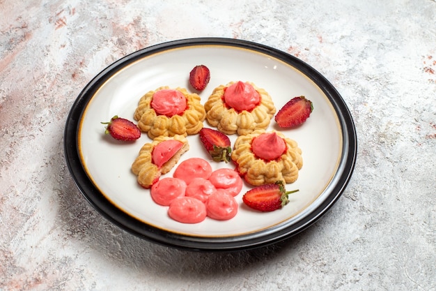 Front view delicious sugar cookies with strawberry jelly on white space