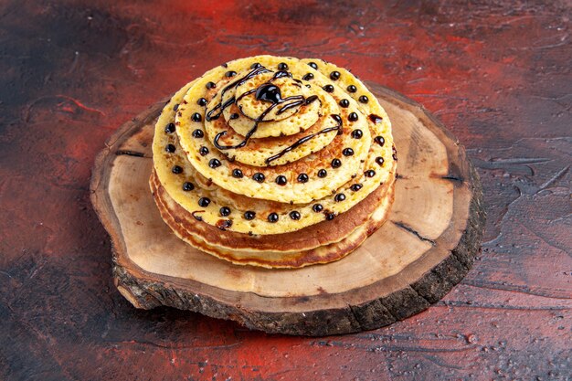 Front view delicious sweet pancakes with icing on dark background