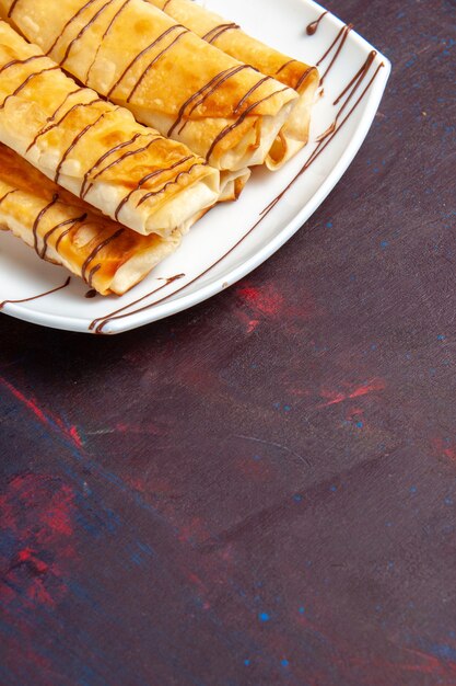 Front view delicious sweet pastries inside plate on dark purple desk