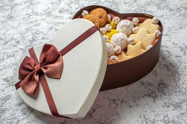 Front view delicious sweets biscuits cookies and candies inside heart shaped box