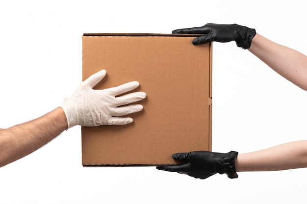 A front view delivery box being delivered from female to male both in gloves on white