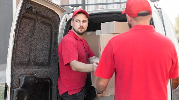 Free photo front view of delivery man with packagaes