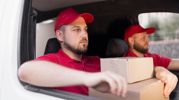 Free photo front view of delivery man with packagaes