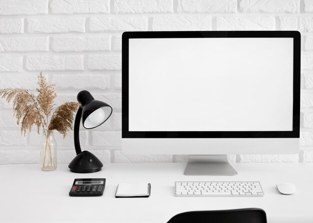 Front view of desk with computer and lamp