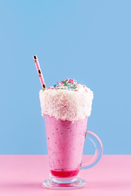 Free photo front view of dessert glass with straw and colorful topping