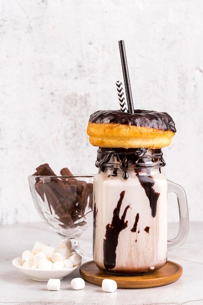 Free photo front view of dessert in jar with marshmallows and straw