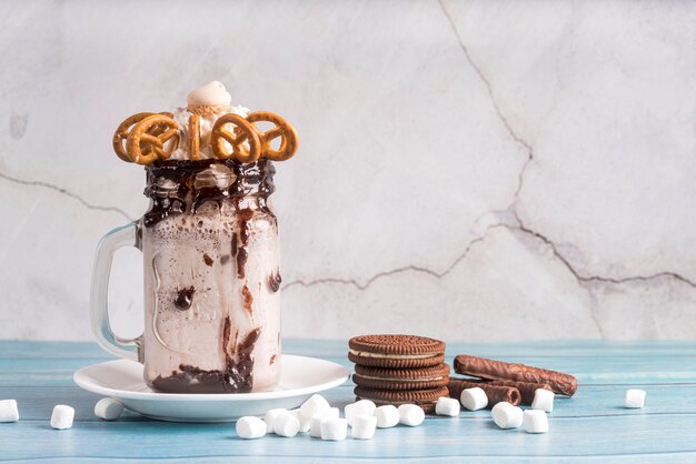 Front view of dessert in jar with pretzels and biscuits