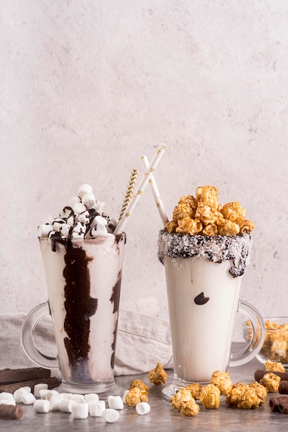 Free photo front view of desserts in jars with marshmallows and copy space