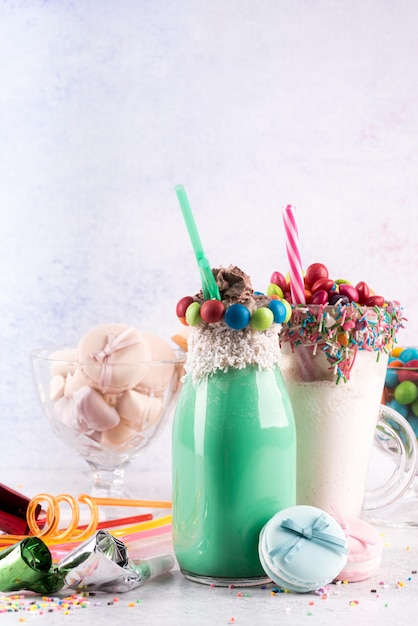 Free photo front view of desserts with colorful candy and straws