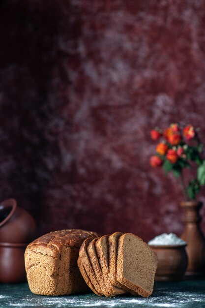 Front view of dietary black bread and bowls flour flower pot on blue maroon colors background