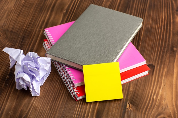 Free Photo front view different copybooks colorful ones on brown surface