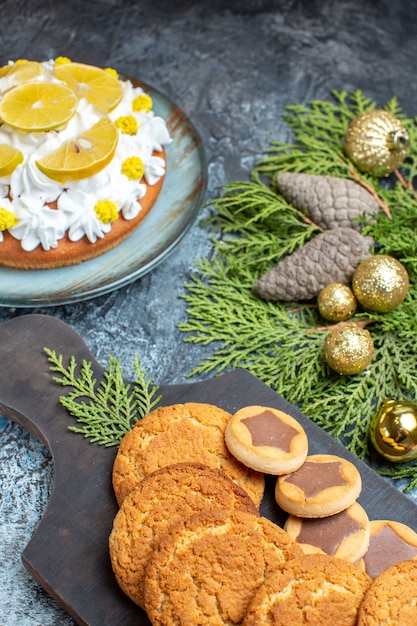 Front view different delicious biscuits with cake on a light-dark surface