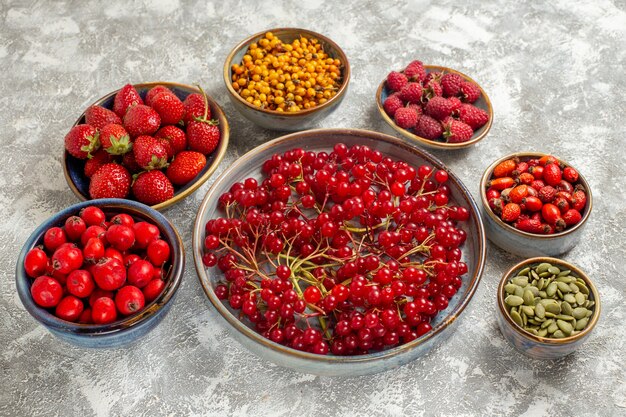 Front view different fresh berries inside plates on white table fruit berry color fresh