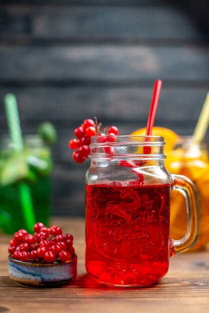 Front view different fresh juices inside cans on brown wooden desk