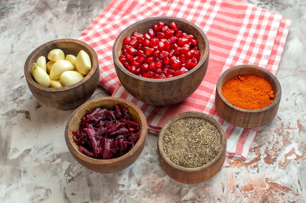 Front view different seasonings garlics pomegranates and beet on light background