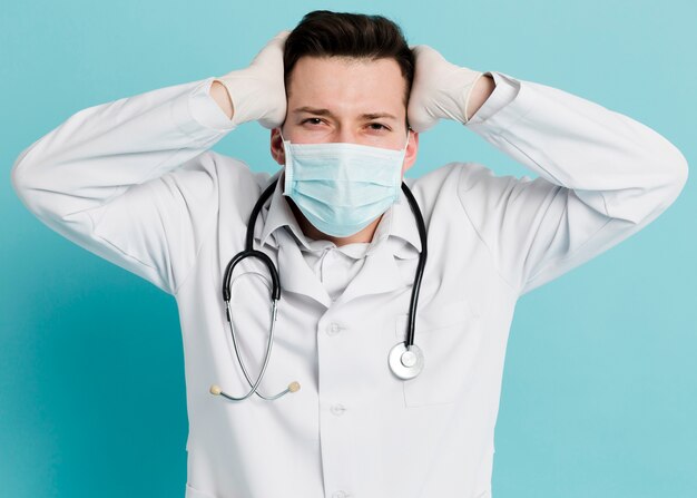 Front view of doctor posing while wearing a medical mask