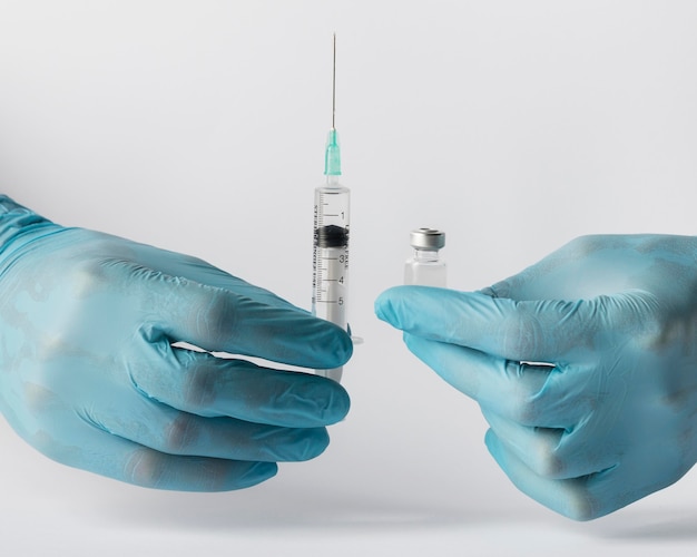 Free photo front view doctor putting a vaccine in a syringe