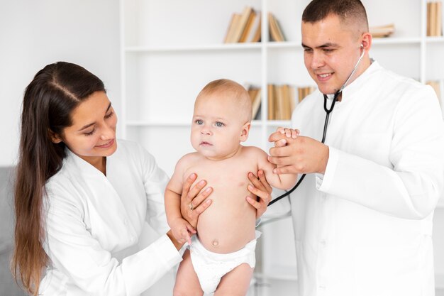 Front view doctors holding adorable baby