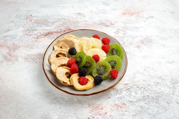 Front view dried pineapple rings with dried kiwis confitures and apples on white surface fruit dry sweet sugar candy