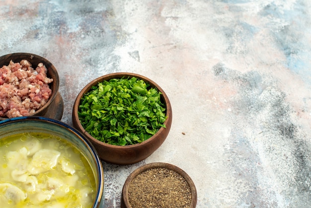 Free photo front view dushbara dumplings soup bowls with meat greens pepper on nude background free space