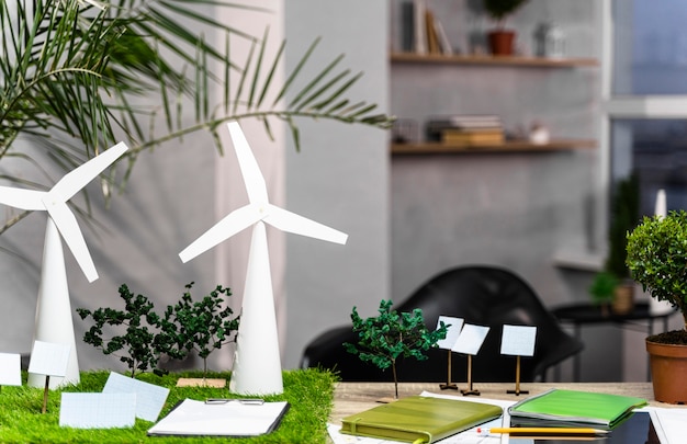 Free photo front view of an eco-friendly wind power project layout with wind turbines on desk