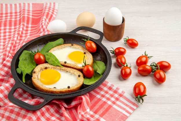 Free photo front view egg toasts inside pan with tomatoes on a white background bread color lunch dish breakfast meal tea food