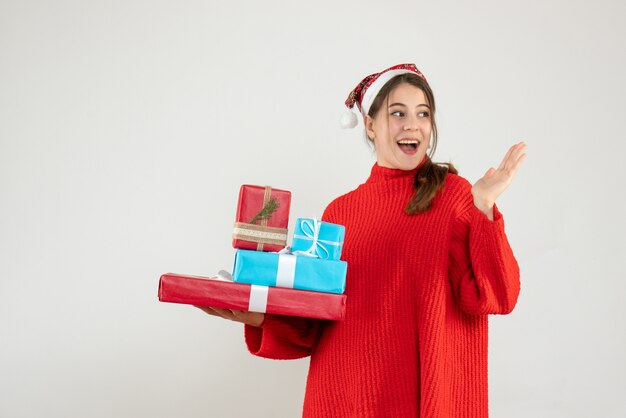 Front view elated girl with santa hat holding her xmas gifts