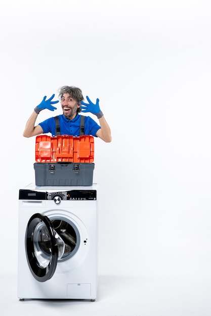 Front view elated repairman opening his hands washing machine on white space