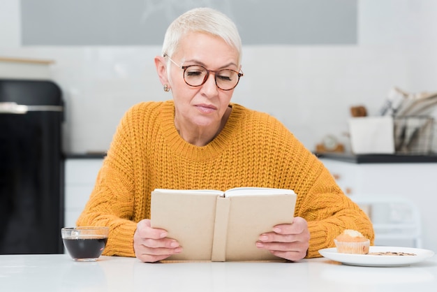 Front view of elderly woman reading a book