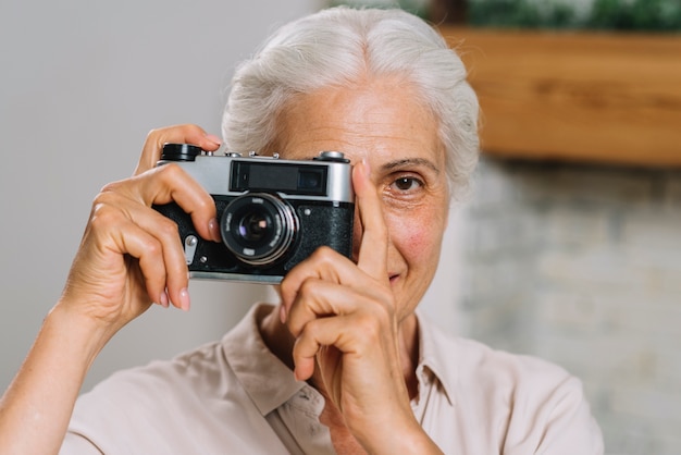 Front view of an elderly woman taking photograph from camera