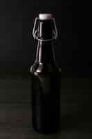 Free photo front view elegant beer bottle on dark background