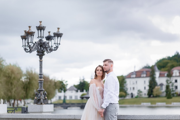 Front view of elegant newlyweds holding hands and looking into the distance