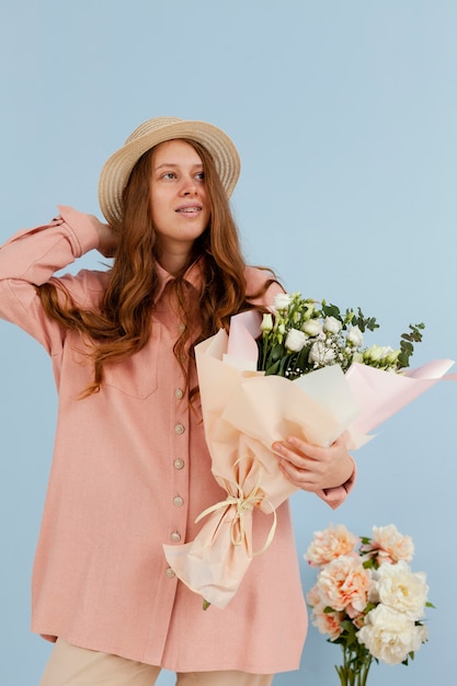 Front view of elegant woman posing with bouquet of spring flowers