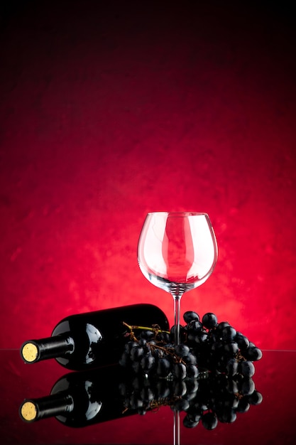 Free photo front view empty wineglass with dark grapes on the pink background