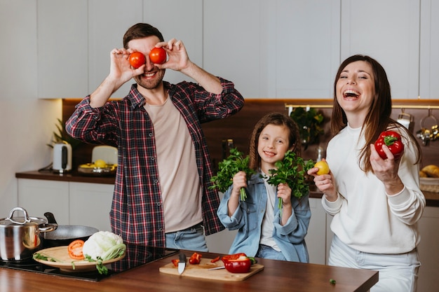 Front view of family having fun while preparing food in the kitchen