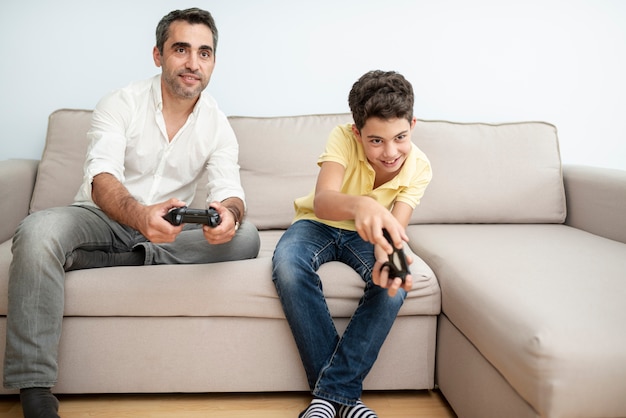 Front view father and child playing with controllers