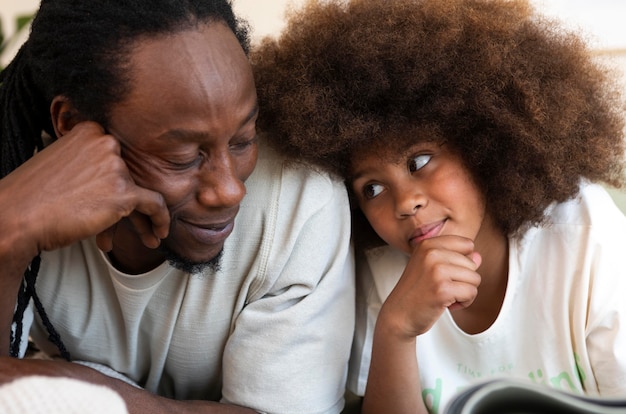 Front view of father and daughter reading a book together