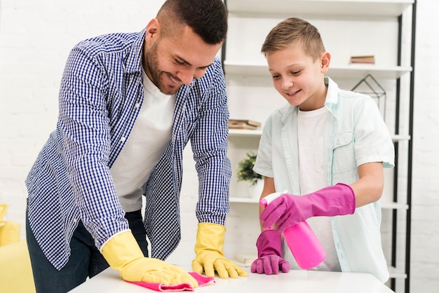 Front view of father and son cleaning the house