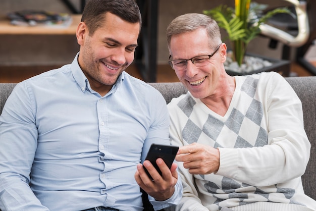 Front view of father and son looking at the phone