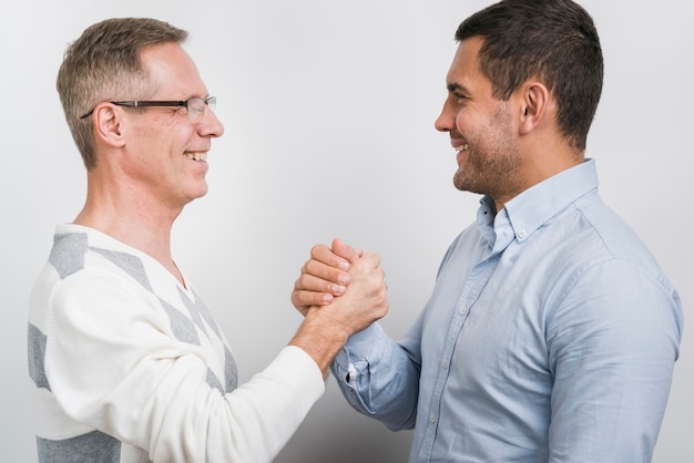 Front view of father and son shaking hands