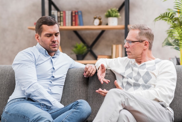 Free photo front view of father and son talking