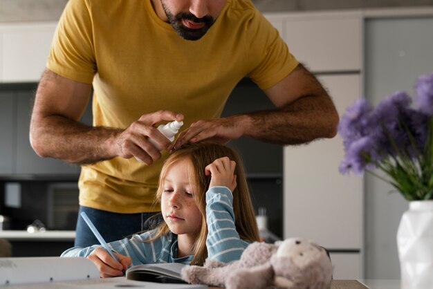 Front view father using lice treatment